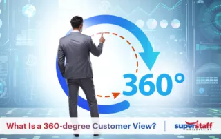 A man has his back on the camera, as he points to a 360-degree customer experience sign on the wall.