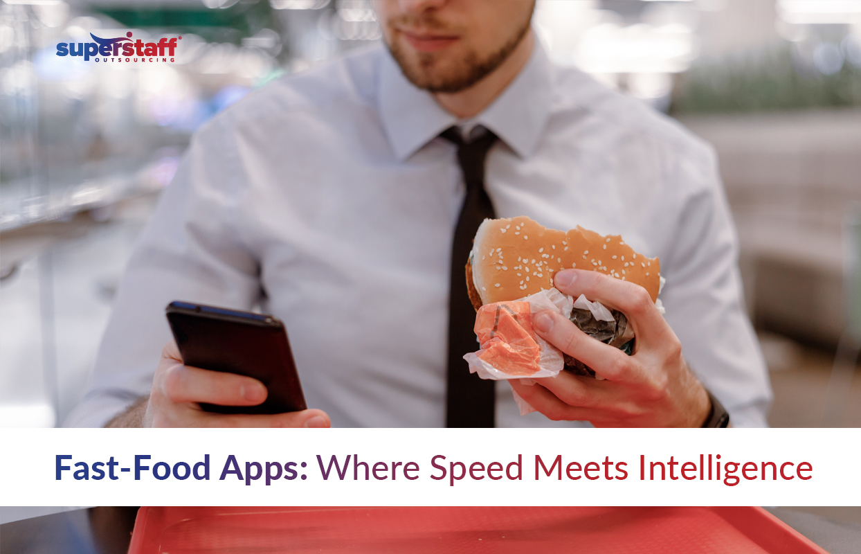 A professionally dressed man holding a hamburger in one hand and checking his smartphone in the other, highlighting convenience and efficiency. The text says, "Fast-Food Apps: Where Speed Meets Intelligence," emphasizing the role of technology in improving fast-food ordering experiences. The SuperStaff logo appears in the top left corner.