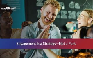 Smiling office workers sharing a light moment, contrasting with common causes of employee disengagement in the workplace