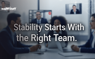 Professionals in a meeting room with remote team members on screens, utilizing reliable staff outsourcing solutions.