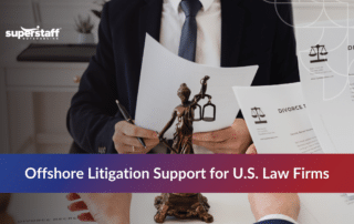Legal professional reviewing case files behind a Lady Justice statue to outsource litigation support services.